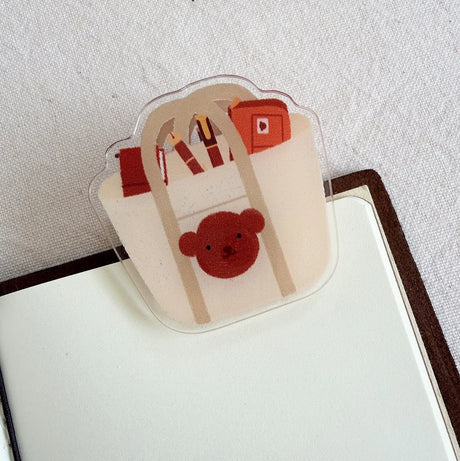 Bloom Paper Studio Acrylic Clip - Choco's Planner Bag

An acrylic clip to hold pages open in your planner, journal, or book! This clip doesn't crease the pages.

- 1.8"x1.4"
- removable clear film on both sides

Note: Colors on screen may appear slightly different in person. By purchasing, you have acknowledged reading this disclaimer.