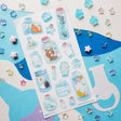 🌙🦊 Bottled up and brimming with magic, @ameruu transforms tiny jars into whole little worlds you can hold in your hands. Sleepy foxes and bears curl up for a nap, twinkling stars sparkle beside crescent moons, and delicate blooms and tiny treasures are tucked safely behind glass. From star-shaped vials to oversized bottles holding fragments of the night sky itself, this sheet is a pocket-sized universe, ready to sprinkle some stardust onto your favorite spreads.

Art by: @ameruu