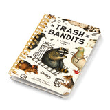 Dumpster chic meets unapologetic attitude in the Trash Bandits Sticker Book—a gloriously messy collection of oversized stickers featuring raccoons, possums, pigeons, and other urban icons with googly eyes and snarky commentary. Whether you're decorating your planner or marking your territory, these critters are here to add some trashy charm to your everyday life.

Inside, you’ll find 18 pages of trash animal stickers + 2 bonus pages of vintage-inspired puffy stickers, all packed with clever quips and chaoti