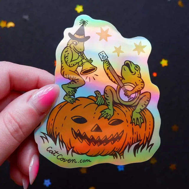 Cat Coven -&nbsp;Halloween Frogs Holographic Vinyl Sticker

Celebrate your love for Halloween with this cute new Halloween frogs vinyl sticker! This sticker is perfect for your journal, water bottle, laptop, and more.

Waterproof, UV protected &amp; high temperature resistant
3 x 3.7 inches and holographic!
Colors may vary slightly from your computer screen to real life product