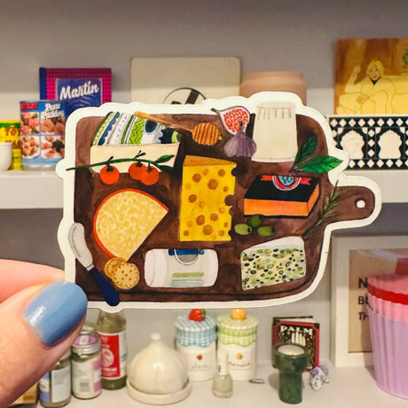 Experience the whimsical charm of Daria Solak Illustrations with the CHEESEBOARD sticker. Sized at 8 cm, it's an excellent adornment for your laptop, notebook, or water bottle. The design is a delightful blend of colour and creativity that will surely bring a smile to your face. All of Daria's designs are born from hand-drawn illustrations and printed locally, with a fondness for quality paper and vibrant colours. The sticker is a testament to her love for drawing everyday themes like girls, animals, and fo