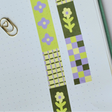 Flower Patch pattern washi tape! This tape featured illustrated florals, checkerboard and a grid pattern in a green, purple and cream colour palette.

This paper masking tape is perfect for decorating your bullet journal and planners, scrapbooking &amp; gift wrapping. It'll add some fun and colour to any surface and is easy to peel off.

10m x 15mm