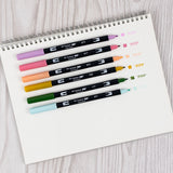 Set of 6 colors. Dual Brush Pens feature a flexible brush tip and a fine tip in one marker. The brush tip works like a paintbrush to create fine, medium, or bold strokes, while the fine tip provides consistent lines. The Teatime palette is inspired by elegant tea blends, featuring soft florals and earthy tones for a refined, calming aesthetic. The water-based ink is blendable, and the resilient nylon brush retains its point stroke after stroke. Colors include: Orchid (673), Mauve (817), Coral (873), Yellow 