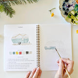 Twelve camping illustrations — a vintage camper, lantern, campfire, tent, canoe, s'mores, and more — each pre-outlined with step-by-step instructions. Paintings take about thirty minutes from start to finish, making it approachable for first-time painters and a favorite for gifting.