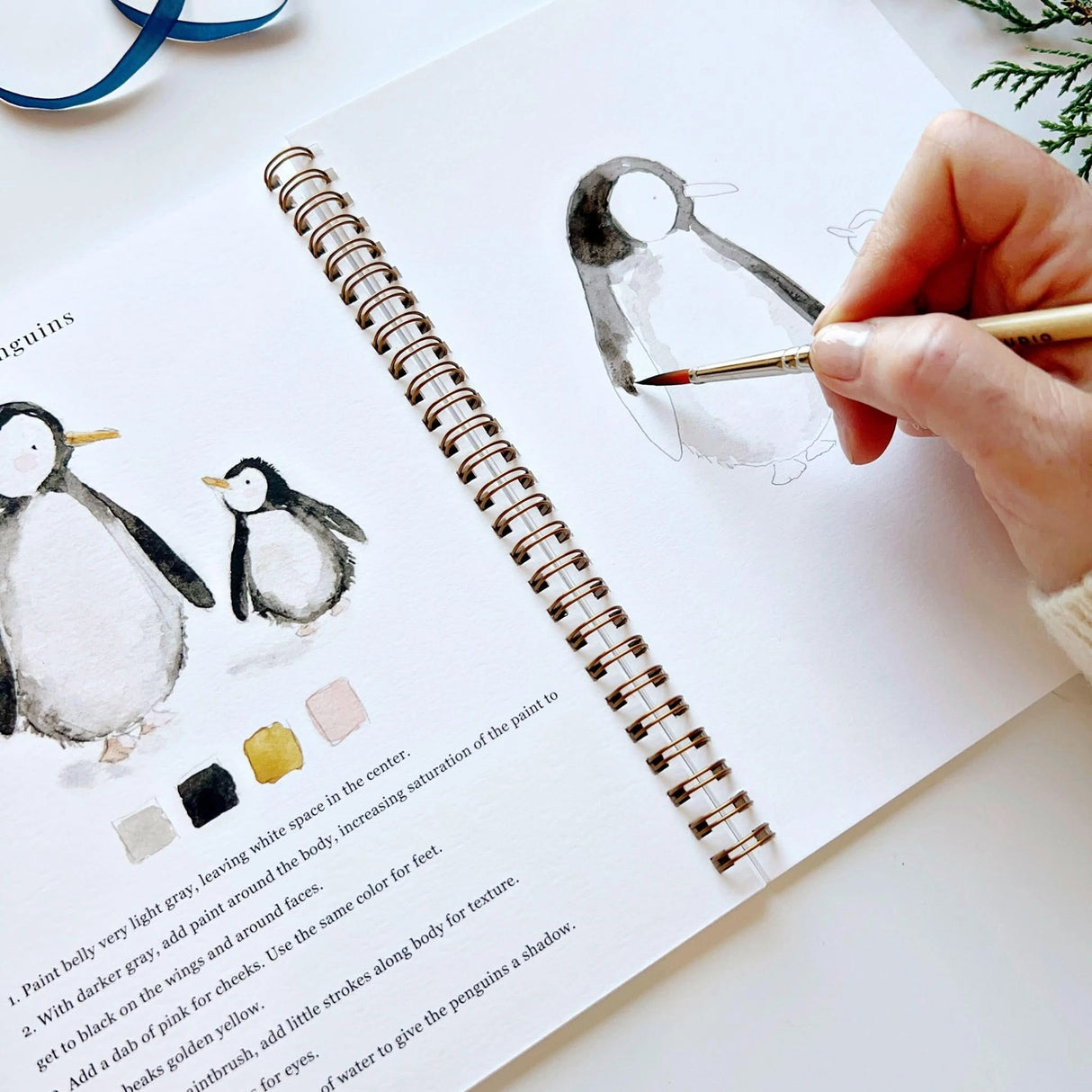 Twelve winter illustrations — a snowman, A-frame cabin, fair isle sweater, snow globe, ice skaters, mittens, and more — each pre-outlined with step-by-step instructions. Paintings take about thirty minutes from start to finish, making it approachable for first-time painters and a favorite for gifting.