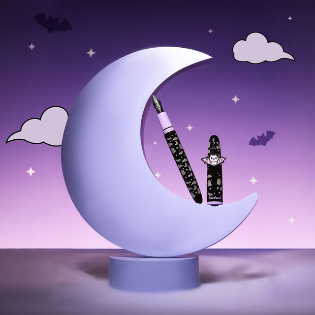 Esterbrook - Sweetly Haunted Estie Fountain Pen

Sweetly Haunted - the cute side of things that go bump in the&nbsp;night. A black barrel is scattered with sweet little ghosts, bats, and stars, with a soft purple&nbsp;accent adding an unexpected pop of color. A removable bat charm brings a little extra&nbsp;Halloween fun, but the subtle, playful design makes this one easy to love long after spooky
season ends. It’s a little dark, a little whimsical, and made for stationery lovers who prefer&nbsp;their haunt