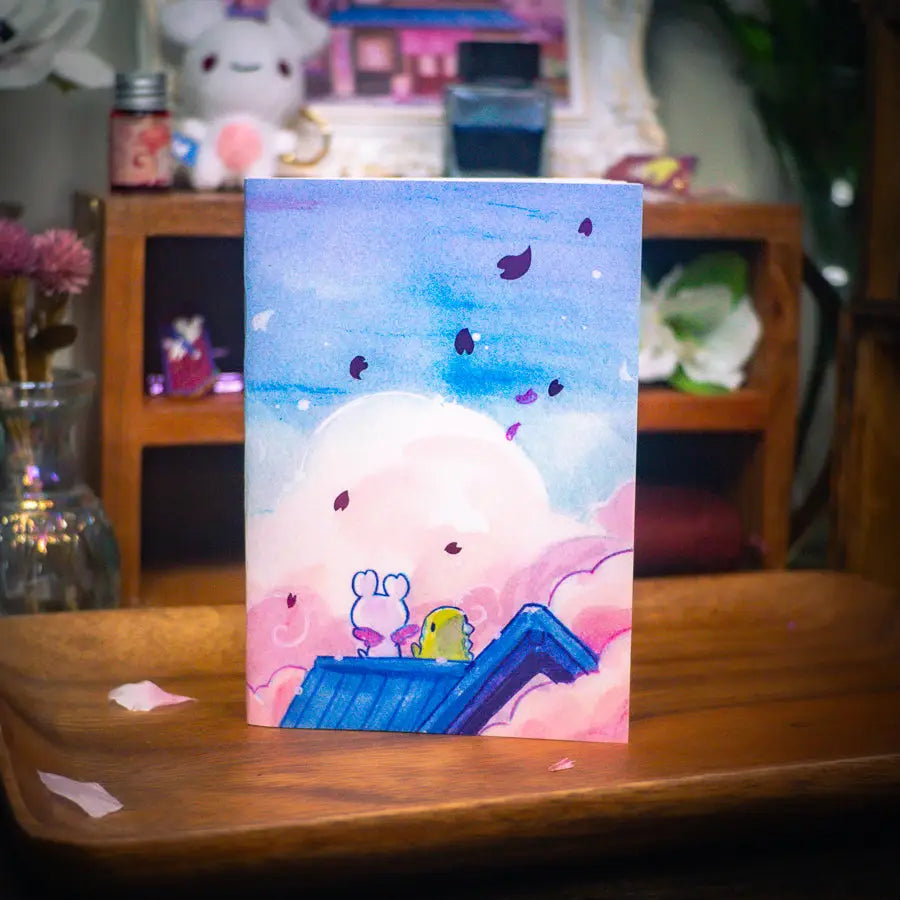 Esterbrook x Sakuradragon - Sakura Street Morning Skies A6 Notebook

Mornings are quiet around here.

Did you notice the pink foil cherry blossoms falling from the sky?

Dimensions: &nbsp;A6 (10.5 × 14.8 cm)
Paper: Double-sided offset paper
Page Ruling: Blank
Pages: 64


Message from sakuradragon: &nbsp;Not all paper and ink are made equal but this paper does a great job with both fountain pens and dip pens. There is minimal ghosting but bleeding does occur with heavy ink usage.