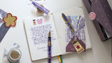 Featuring original Sakura Street illustrations by Cindy Duong, this five-piece blotter paper set adds the collection's colorful imagination to a useful fountain pen accessory. The papers can be used to absorb excess ink while writing or as decorative placeholders and bookmarks within a journal.