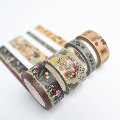 Set of decorative tape rolls with nature-themed designs on a white background. Add a dash of whimsy to your creative space with the Field Mouse Washi Tape Set. Featuring soft florals, cozy textures, and tiny mouse illustrations, this charming set brings a sweet woodland story to life across four unique rolls