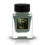 Forbidden Forest is a soft, misty green with blue-grey undertones and warm golden-brown shading. The color evokes morning fog drifting through ancient woodlands, where sunlight filters through moss-covered branches. In heavier applications, the ink deepens into rich teal-grey pools, while lighter strokes reveal a delicate, ethereal sage green. The contrast between cool forest tones and warm amber edges creates a beautifully organic, weathered appearance.