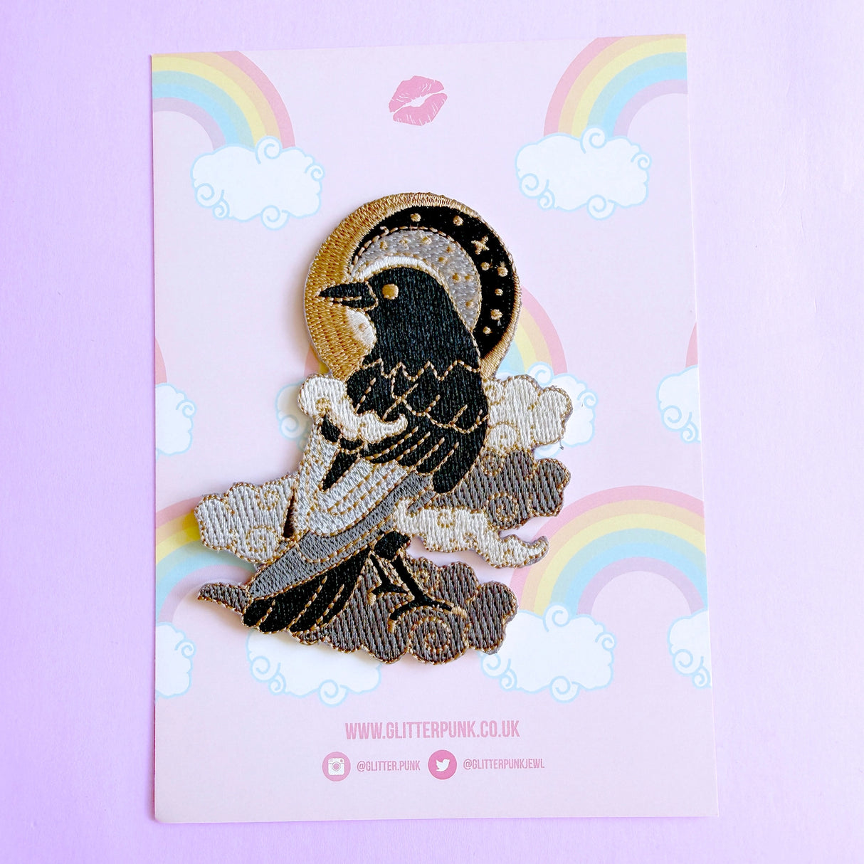 This fabulous patch features a black crow surrounded by grey glittery clouds, and a starry moon with grey backgrounds.

Beautifully woven with black, white, grey & gold threads, this fabulous patch with brighten up any coat, bag or hat!

Measurements: 70mm x 90mm