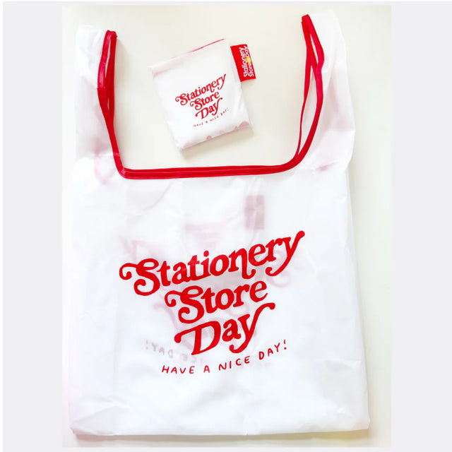 Stationery Store Day 2026

Polyester foldable tote with art by Karen Schipper

Bag is 14.25" W x 3.25" D x 22.5" H with a 6.7" handle drop.
Folds into pouch appx 4.25".
Red trim and cute SSD tag!