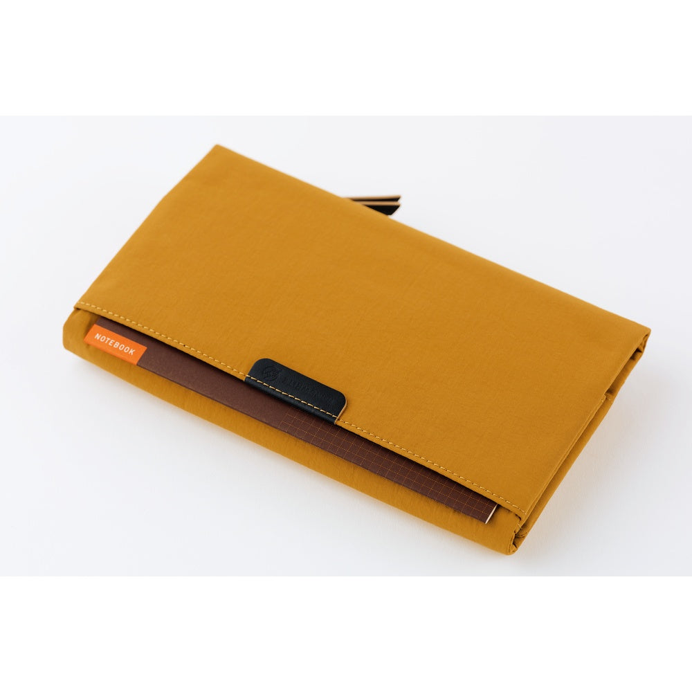 On the back is another handy pocket for quick-access items like tickets or small notebooks. A “HANDWRITE” tag adds a playful finishing touch.
