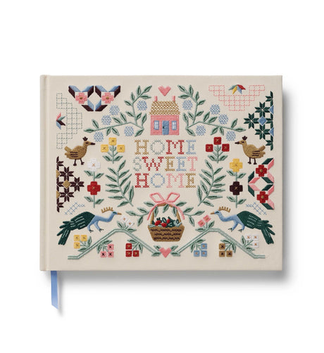 A one-of-a-kind keepsake, our embroidered guest book is a large, hardcover journal with 144 interior pages, half lined and half blank so guests can write a note, add a sketch, or paste a photo. The cover is wrapped in book cloth and embroidered. A grosgrain ribbon bookmark saves your place.

DETAILS
- Book cloth cover with 100gsm ivory uncoated paper
- Natural white text paper
- Embroidery on front cover
- Grosgrain ribbon bookmark
- 144 lined and blank pages
- Lay-flat finding
- Acid free paper
- 10.25" W 