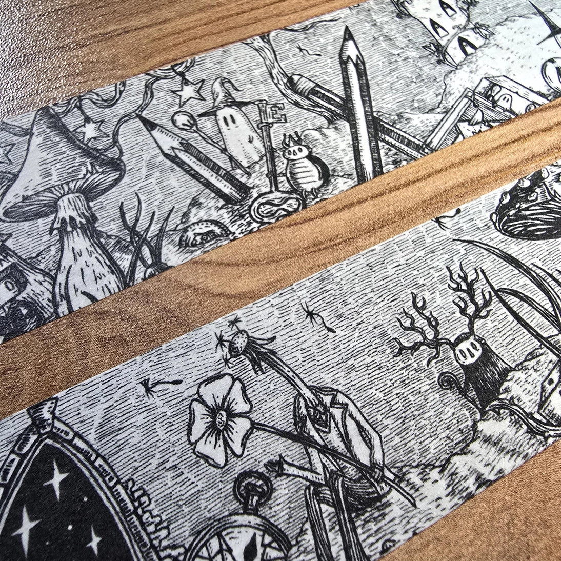 A unique and infinitely repeating fantasy landscape of melancholy oddities and curious characters, from original hand-drawn ink artwork by Jon Turner, recreated with incredible detail at miniature size in this washi tape that invites you to find new tiny details with every viewing.

This is a special extra-wide washi tape, 30mm high which really brings out all the tiny details. perfect for creating a decorative border when journalling, or for packing parcels with surreal style. 10m long.