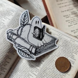 A studious little ghostie catching up on a bit of reading, on a lovely die-cut vinyl sticker, from an original ink illustration by Jon Turner.