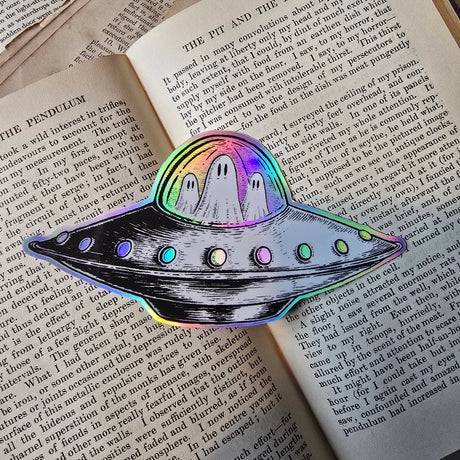 A spooky little UFO on a lovely die-cut holographic vinyl sticker from original pen and ink artwork by Jon Turner.