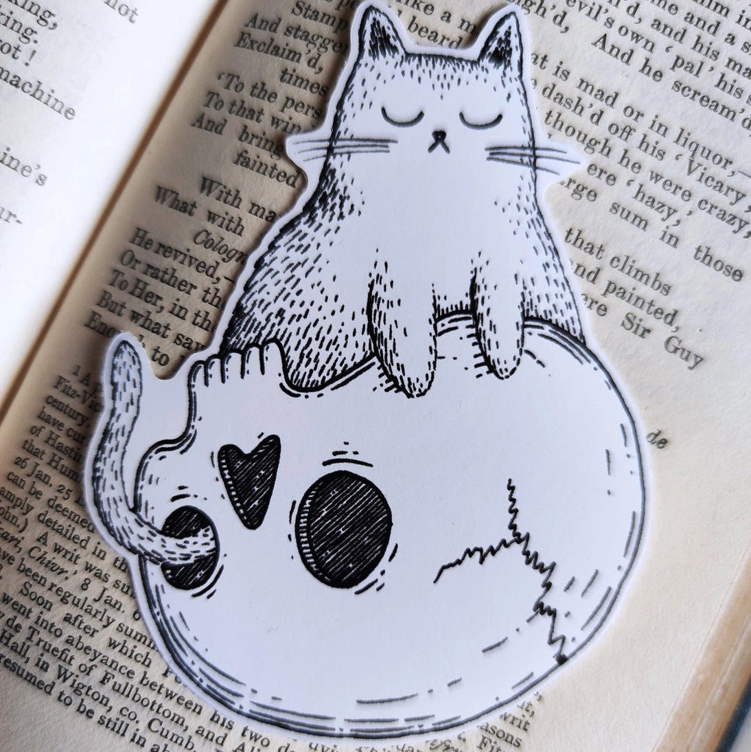Sticker featuring a spooky little cat sitting contentedly on a skull, from my original pen and ink artwork.

Die-cut vinyl sticker, suitable for interior or exterior use. Measures approximately 7.5cm (3 inches) high, and 5cm (2 inches) wide.&nbsp;