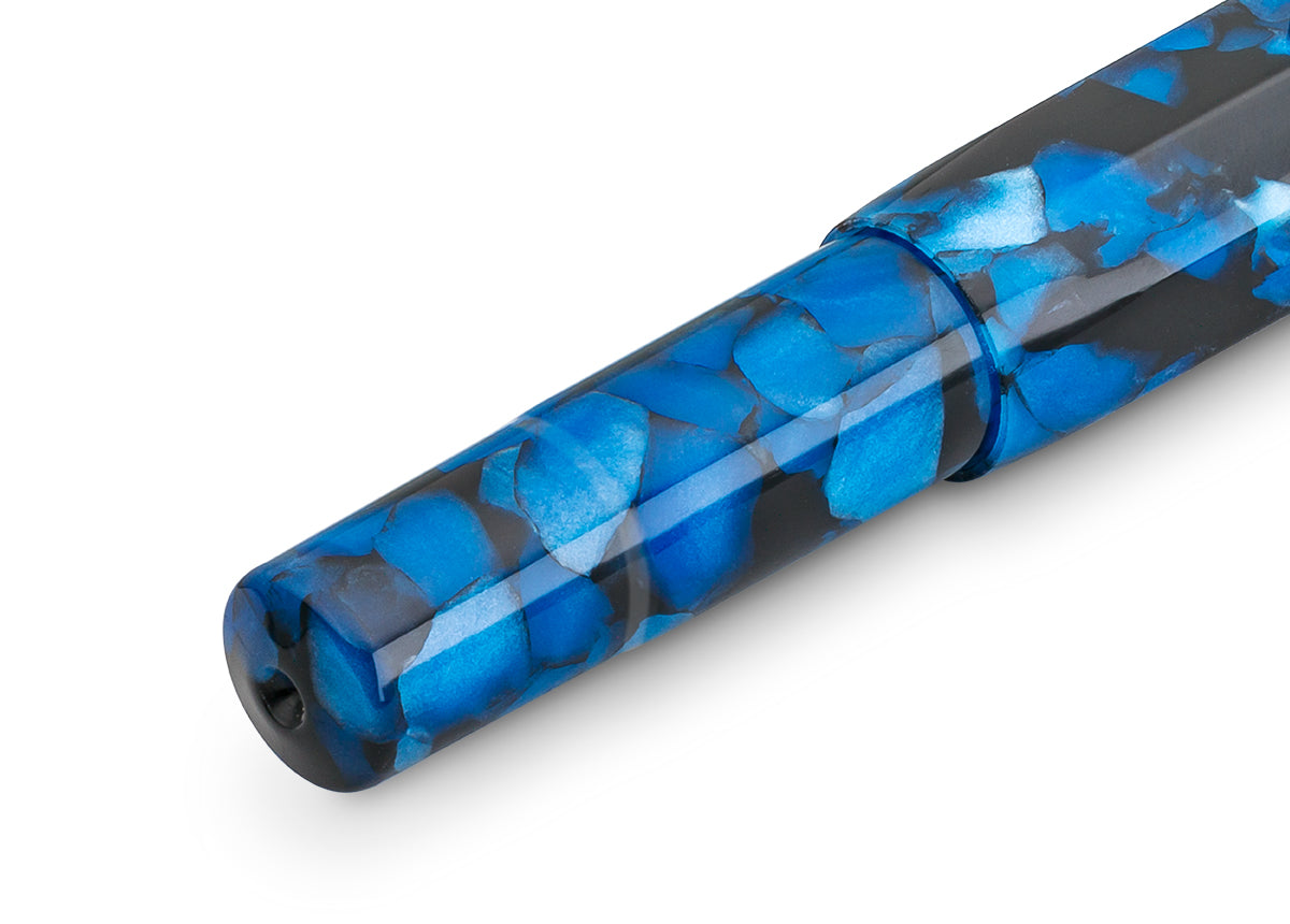 The Kaweco sports model in a nostalgic look

An excellent writing experience in its most impressive way – the Kaweco Art Sport fountain pen in the colour Pebble Blue bursts with timeless elegance. The interplay of the deep black and the blue shimmering inlays makes the writing instrument made from high-quality acrylic a particularly noble collectible and eye-catcher. The different intensities of the blue shade and the glossy, highly polished surface create a fascinating excitement and depth. Unique textures