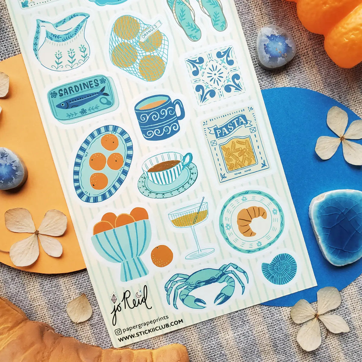 🩴🍊 @papergrapeprints is serving up a sun-soaked spread of seaside favorites, and we’ll take one of everything! Bright oranges, sardines, pasta, pretty ceramics, hydrangeas, and that perfect blue crab come together in a dreamy mix of coastal color and vacation-day charm. Add flip-flops, something cold to sip, and absolutely zero plans. Art by: @papergrapeprints

Top Coating: None
Adhesive Layer: Paper
Backing Layer: Clear PET
6.69" x 3.54".
Weight - 0.03lbs
1 sheet included