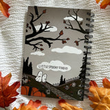 A new A5 notebook featuring ghosties strolling through the cemetery!

This hardcover notebook comes lined and with an elastic band. There are 96 double sided pages.