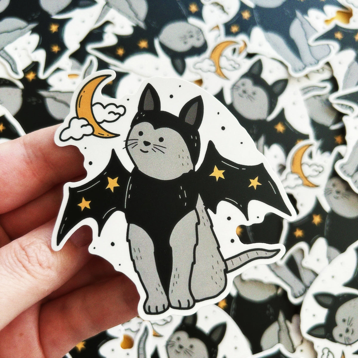 Little Spooky Studio - Vampire Cat Vinyl Sticker

A gray cat wearing vampire wings and matching hat with stars!