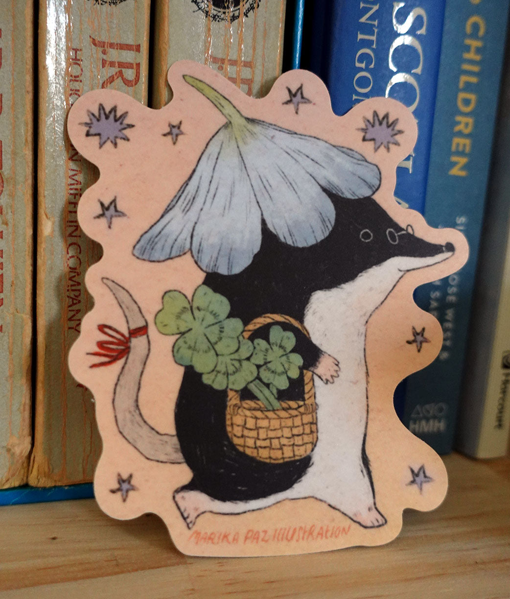 A shrew goes for a walk with some luck in their pocket! This vinyl matte sticker is weather and waterproof-stick it on a notebook, bike, or car- it's going to stick around! Heck, throw it on a water bottle and through the dishwasher. This sticker can go anywhere.

Sticker measures 3" x 4"

Printed in USA.
