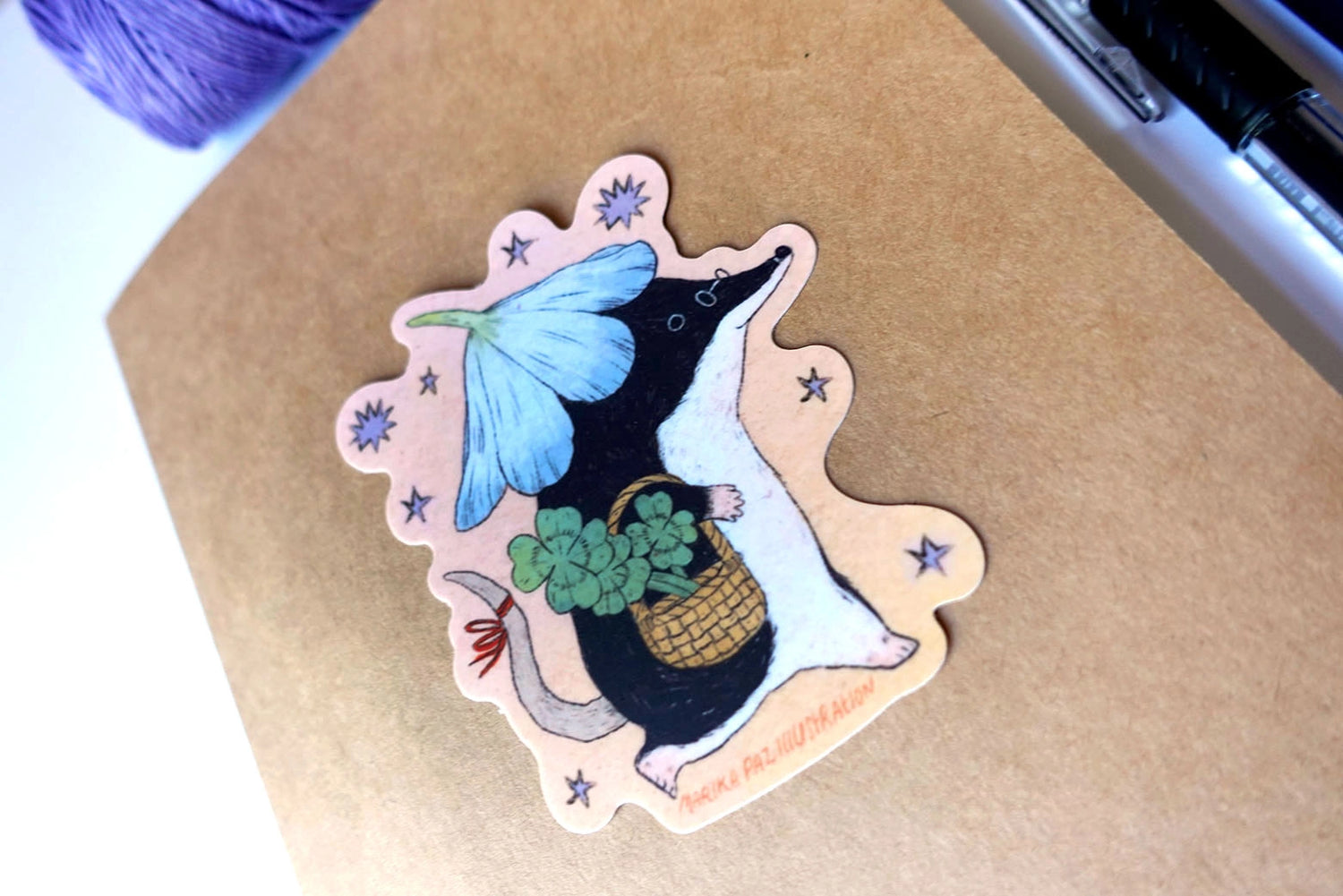 A shrew goes for a walk with some luck in their pocket! This vinyl matte sticker is weather and waterproof-stick it on a notebook, bike, or car- it's going to stick around! Heck, throw it on a water bottle and through the dishwasher. This sticker can go anywhere.

Sticker measures 3" x 4"

Printed in USA.