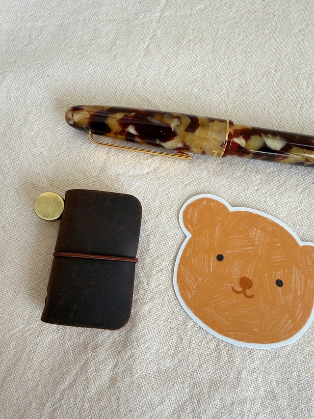 This mini leather journal can be used as a keychain or to keep small notes! There is a tiny notebook inside that is fountain pen friendly. Comes with 1 leather journal - 1 phone charm