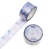 Drift into a dreamy underwater world with this stunning Nostalgic Jellyfish Clear Tape from SAIEN. Designed on a transparent base, this tape features softly floating jellyfish that glow beautifully when layered over planners, journals, and craft projects. The delicate artwork paired with shimmering hologram foil creates a magical, ethereal effect, like watching jellyfish drift through sunlit water.