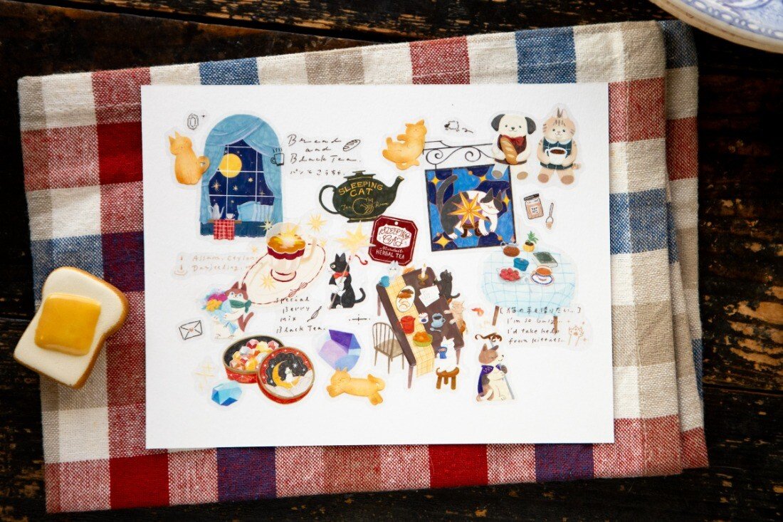 Welcome to the Tea Room! This kiss-cut PET Tape features a relaxing teahouse filled with cats and other furry friends. It adds the perfect touch of warmth to your journal pages with hints of golden brown and dark blue as conversations continue until midnight.