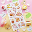 🌸🍰 Welcome springtime sweetness! This adorable sheet by @littlehecki is bursting with sakura magic and yummy café treats. From fluffy shortcakes and swirly cream rolls to dreamy parfaits, sakura cupcakes, and pastel milk teas, every dessert feels kissed by cherry blossoms. It’s like a cherry blossom picnic in sticker form — petals drifting through the air, sunshine on your cheeks, and sweet seasonal treats all around.

Art by: @littlehecki

Top Coating: None
Adhesive Layer: PVC (plastic)
Backing Layer: Cl