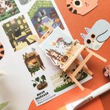 📚🐈 Tucked between cozy rooms, leafy corners, and pages waiting to be explored, @havenpeckover’s curious cats are keeping very busy! These creative kitties paint portraits, curl up with books, play with yarn, tend to their plants, and settle in for quiet study sessions with tea and cookies. A charming little sheet for anyone who believes work is better with a cat nearby, and play is basically required between chapters.

Art by: @havenpeckover