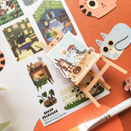 📚🐈 Tucked between cozy rooms, leafy corners, and pages waiting to be explored, @havenpeckover’s curious cats are keeping very busy! These creative kitties paint portraits, curl up with books, play with yarn, tend to their plants, and settle in for quiet study sessions with tea and cookies. A charming little sheet for anyone who believes work is better with a cat nearby, and play is basically required between chapters.

Art by: @havenpeckover