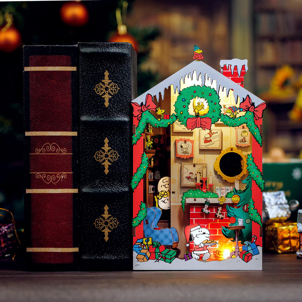 Snoopy Santa surprise! Bring the magic of the holidays to your bookshelf with this charming DIY book nook kit featuring Snoopy dressed as Santa! Caught cookie-handed, Snoopy steals the show while Charlie Brown and Sally peek from the stairs in festive wonder. With delightful details and nostalgic cheer, this cozy scene is perfect for Peanuts fans and holiday decorators alike.