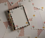 130 linen-textured sheets with metal gold accents and a gold pen with black ink in a reusable desk organizer.