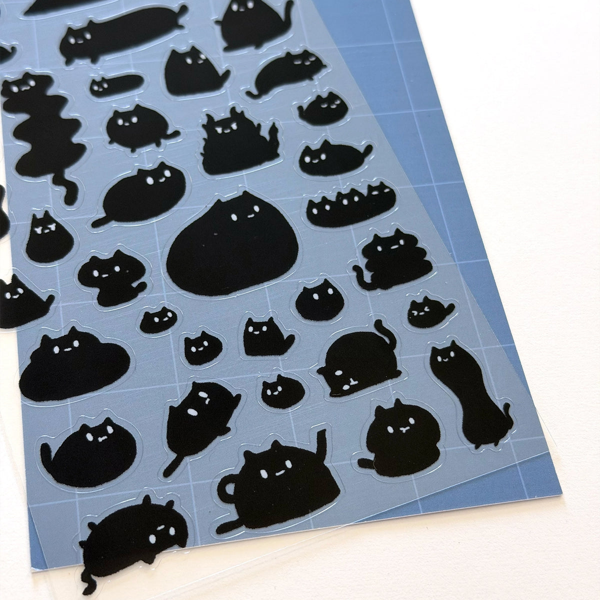 This is part of a new series of sticker sheets that feature different "days".

This one features Sumi the cat on an odd day.

There are 39 individual stickers on the sheet.

They are plastic stickers on a plastic sheet with a backing card and packaging that's ready to display.

The whole packaging is 3.8 x 8.75" and is ready to hang.
The sticker sheet is 3.75 x 5.8"