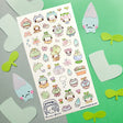 💧🌱 Spring is here, and a sprinkle of rain has brought @wooqiart’s kawaii garden to life! Cuties in froggy hoods and sprouty hats step out to enjoy the season among happy garden friends. With pastel raindrops, leafy umbrellas, and fresh flowers, we wish every drizzly day could be this adorable!