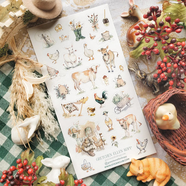 🐄🌾 Morning chores look especially sweet on @gretchenellenkopp’s gentle farmstead, where calves wear floral garlands, ducks waddle in their finest bonnets, and chickens roam between fresh linens on the line. From bouquets tucked into rain boots to honey jars, egg baskets, garden carts, and cozy little workroom corners, this set is full of soft little farm charm.

Art by: @gretchenellenkopp

One sticker sheet is included.
• Top Coating: None
• Adhesive Layer: Paper
• Backing Layer: Paper
• Size: 9x17cm
• 6.