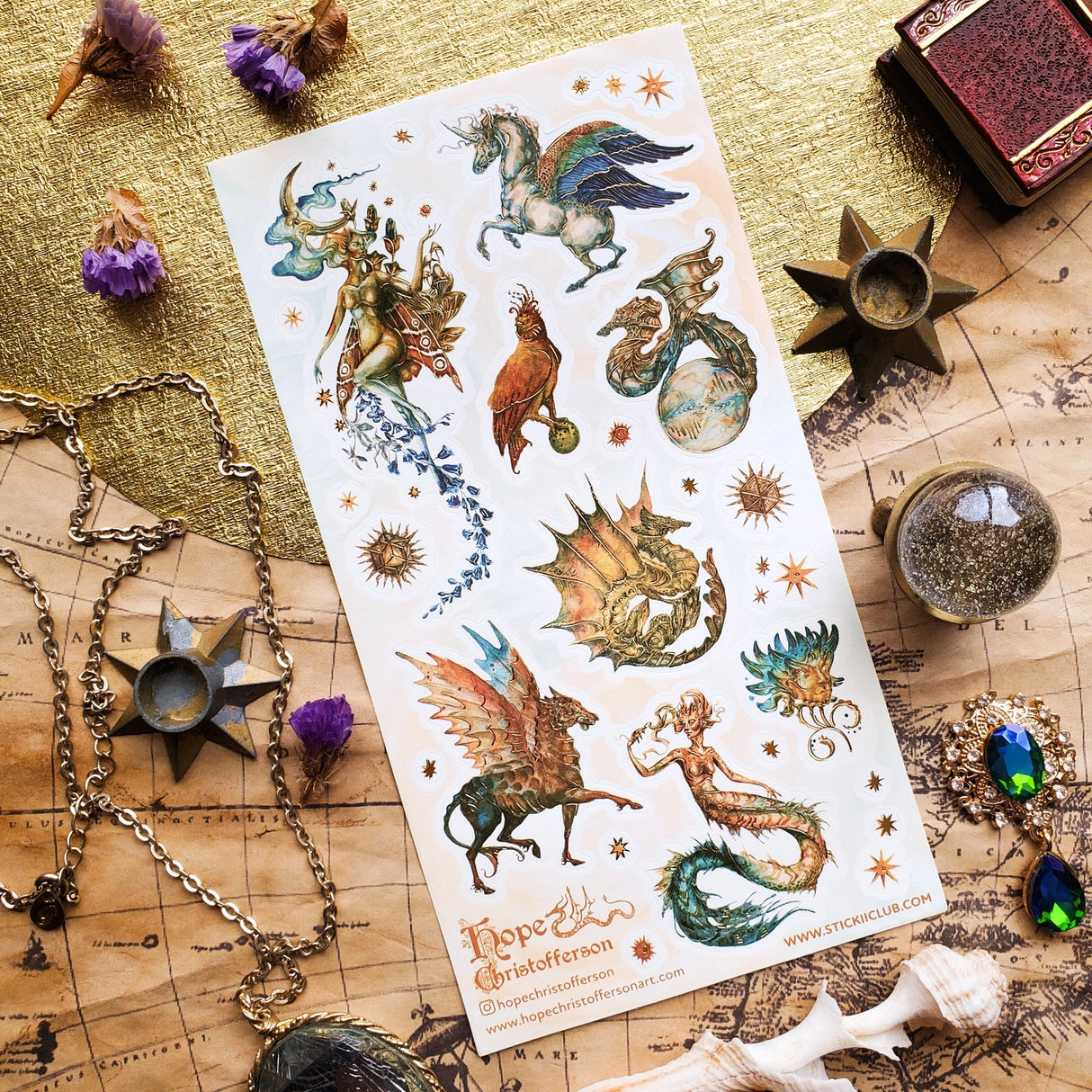 🦄🐉 Soaring through starlit skies and shimmering seas, @hopechristofferson’s mythical beings awaken a realm of untamed magic and ancient wonder. From a winged alicorn and celestial dragons to radiant sirens and cosmic creatures, get ready to weave epic fantasy tales and fill your pages with legendary beauty with this breathtaking sheet.

Art by: @hopechristofferson

Top Coating: Gold Foil
Adhesive Layer: Paper
Backing Layer: Paper
6.69" x 3.54".
Weight - 0.03lbs.
1 sheet included 