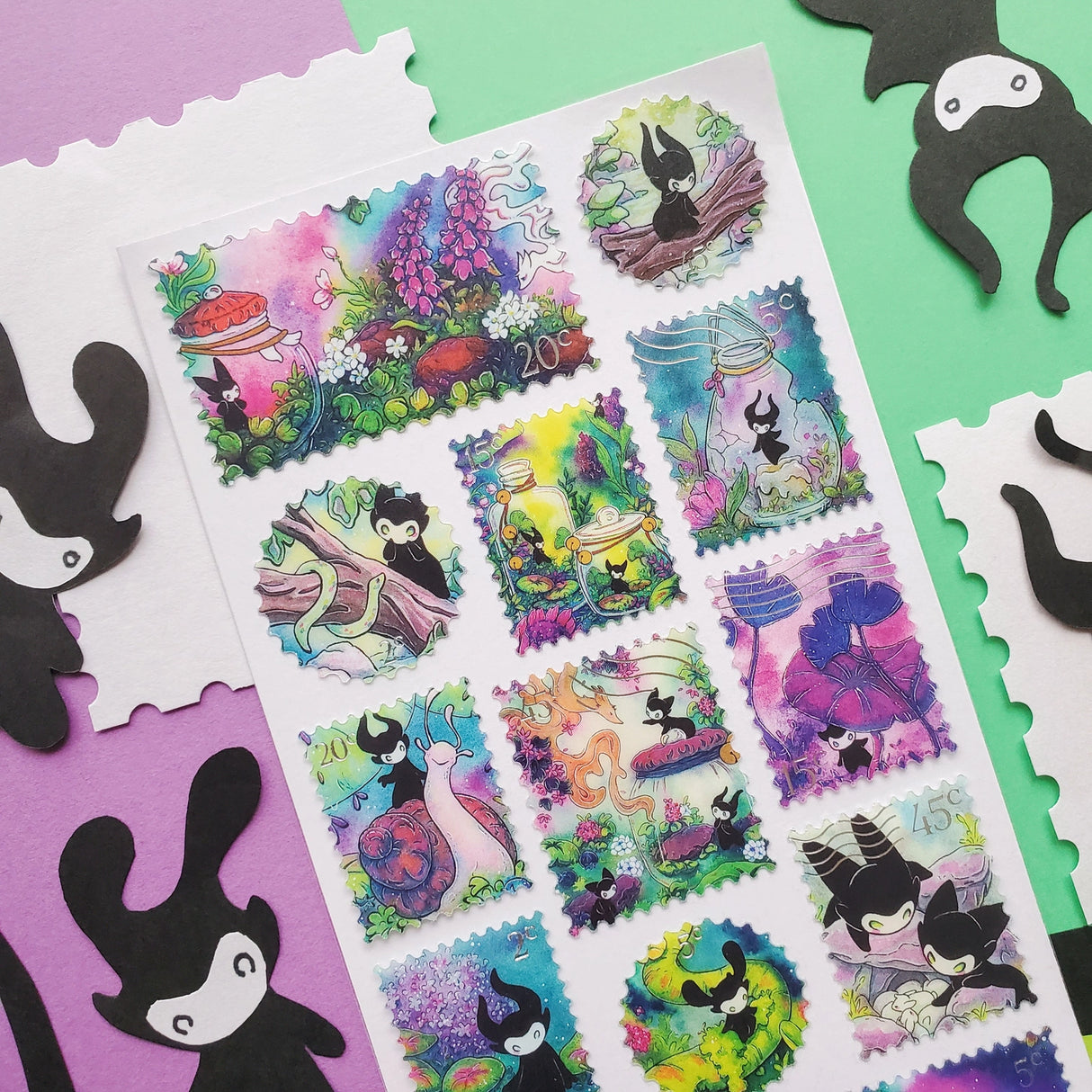 🌳🍄 Stamp your passport and hang on to it tight or one of these cuties might get curious! This whimsical sheet by @pabkins features curious little forest spirits that dart between mushrooms, bottle secret spells, ride friendly snails, and splash through ancient streams. They got a penchant for exploring, and they want you to join (sometimes unknowingly!)

&nbsp;Art by: @pabkins

Top Coating: Silver foil&nbsp;
Adhesive Layer: Paper&nbsp;
Backing Layer: Clear PET
6.69" x 3.54".
Weight - 0.03lbs.
1 sheet incl