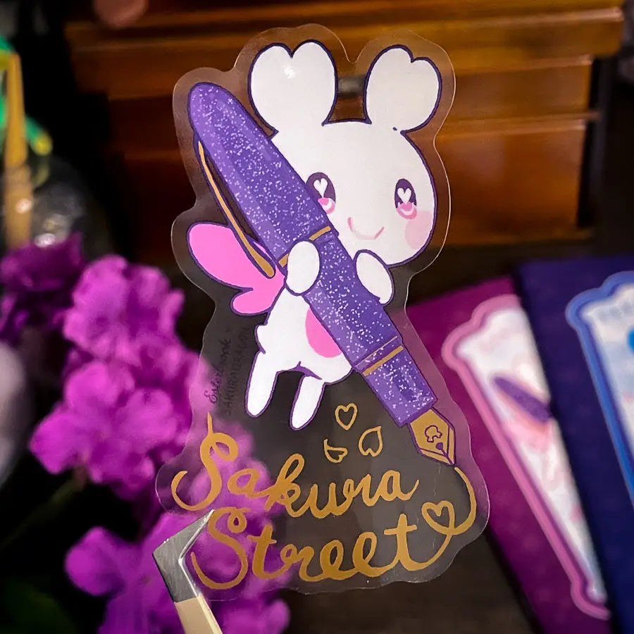 Sakuradragon - Sakura Street Fountain Pen Clear Vinyl Sticker

Sakuradragon really look like she's shining with that pen.

Product Details:

• Material: PET (clear plastic - oil proof, UV resistant, and waterproof)
• Dimensions: 3.5in x 2.37in
• Foil: Gold