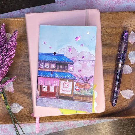 Sakuradragon - Sakura Street Shopfronts A6 Notebook

Cozy little shop fronts that you will find on your walk down Sakura Street. Did you notice the pink foil cherry blossoms falling from the sky?

Dimensions: &nbsp;A6 (10.5 × 14.8 cm)
Paper: Double-sided offset paper
Page Ruling: Blank
Pages: 64


Message from sakuradragon: &nbsp;Not all paper and ink are made equal but this paper does a great job with both fountain pens and dip pens. There is minimal ghosting but bleeding does occur with heavy ink usage.