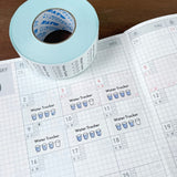 Stamp Marche Planner Label Sticker Roll - Water Tracker Roll of tape with water tracker labels on a calendar page