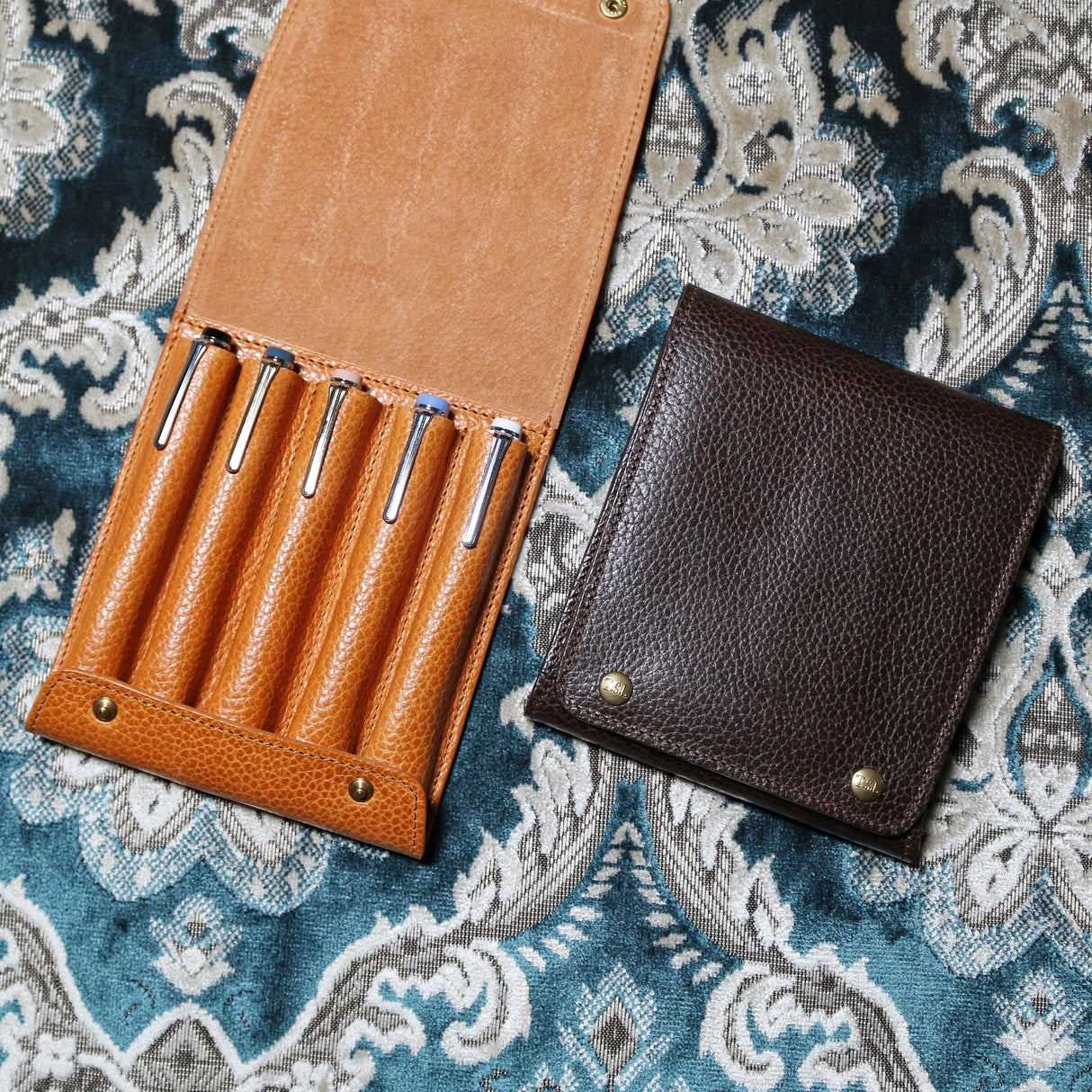 This case for fountain pens can hold five pens individually.

Lined with pig suede for a luxurious look and feel, your precious pens will be well protected and carried.

The buttons are original, made of solid brass and stamped with T.S.L.

SIZE :&nbsp;L13cm × H15cm


COLOR : Camel / Brown&nbsp;/ Black


MATERIAL :&nbsp;Cow leather

Leather Products:

The leather used in this product is natural leather.
We do not use scratches that lead to tears or rips, but we use scratches and wrinkles that are originally