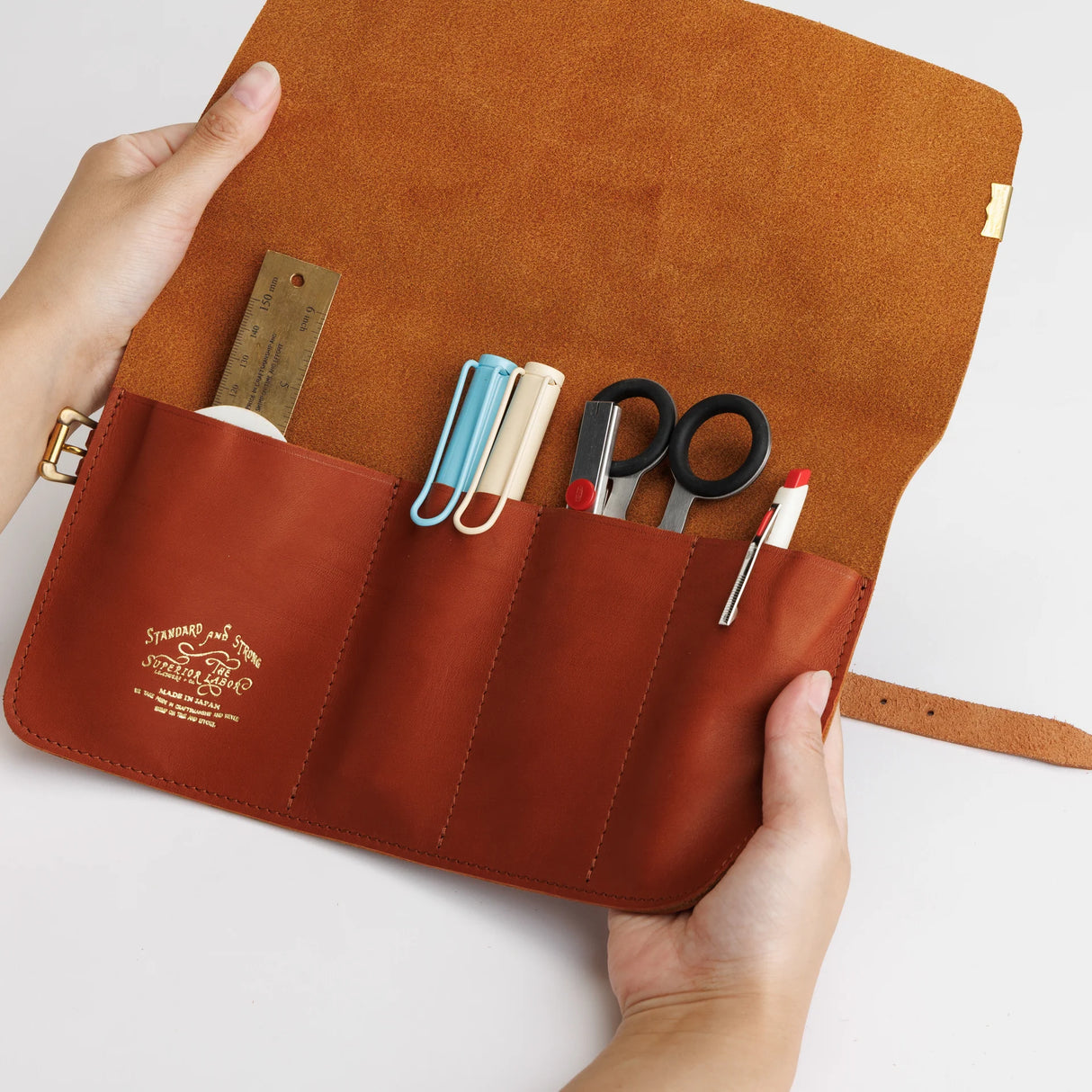 The SUPERIOR LABOR Glove Leather - Roll Pen Case

The discontinued&nbsp;pen roll&nbsp;has returned with a refined new design.&nbsp;A brass tag accents its raw-cut edge, while the logo inside is finished with elegant gold foil.&nbsp;The result is a fresh look that feels both light and sophisticated.

Pockets in varying sizes hold pens of different types, and when you’re done, simply roll it up and take it with you.

A pen case that combines the joy of displaying your favorite pens with the practicality of ca