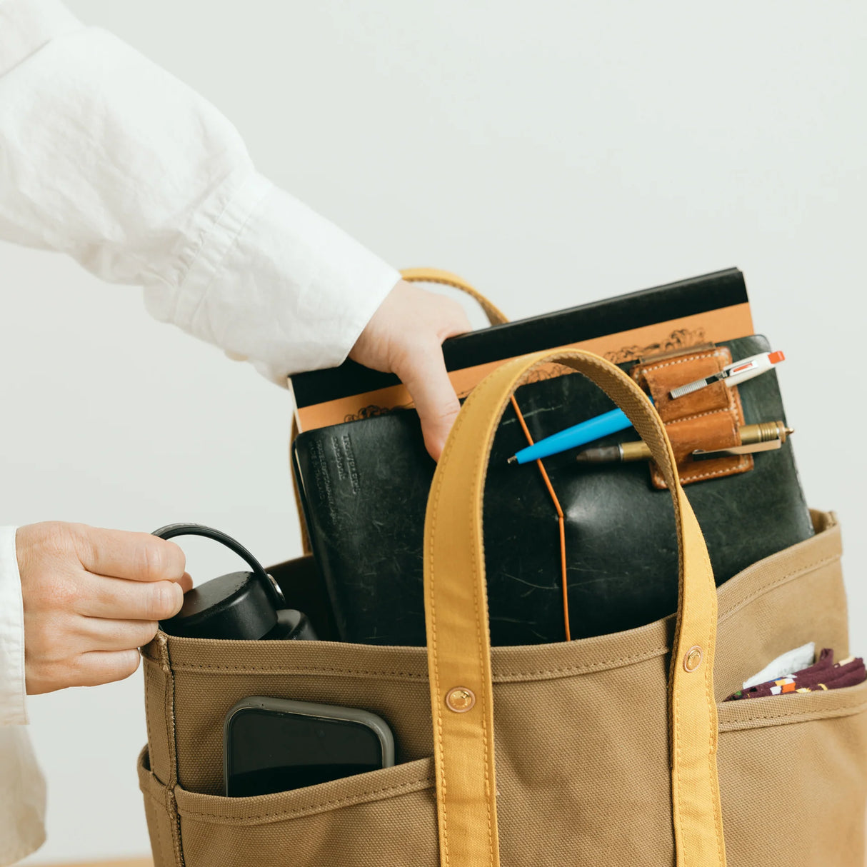 The SUPERIOR LABOR Mini Tote Bag

A simple, timeless canvas bag designed for everyday life.

Its compact size is just right for daily essentials, while the four outer pockets keep your glasses, keys, favorite pens, or notebook neatly organized.

They make it easy to stay tidy and add a touch of extra storage without changing the clean look of the bag.

Size: W37×H23.5×D12.5cm
Canvas Products
Painted areas may be affected by friction or water, which can cause color transfer. Please handle with care.