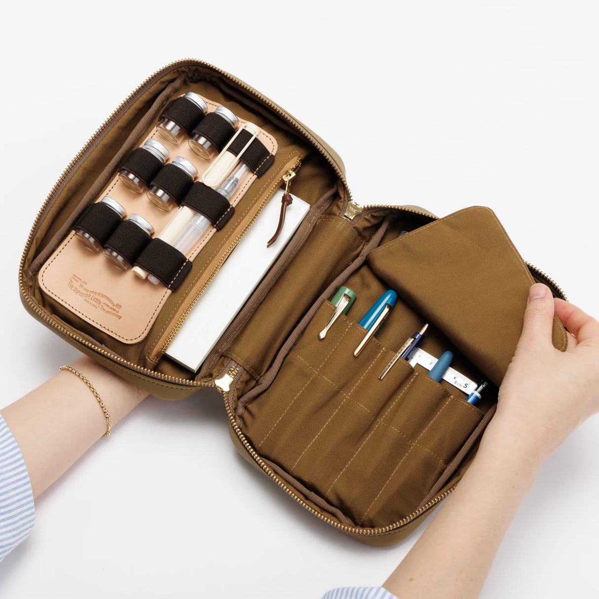 The SUPERIOR LABOR Painter's Leather Case

We created this leather case for those who love to draw —for artists who find joy in carrying their tools and capturing inspiration wherever it appears.

This case has two key features.&nbsp;The first is its ample storage capacity, designed to hold many long pens such as brush pens that are perfect for sketching and illustration.&nbsp;The second is a set of elastic bands made to fit small ink bottles, ideal for those who prefer using dip pens.(Compatible with glass