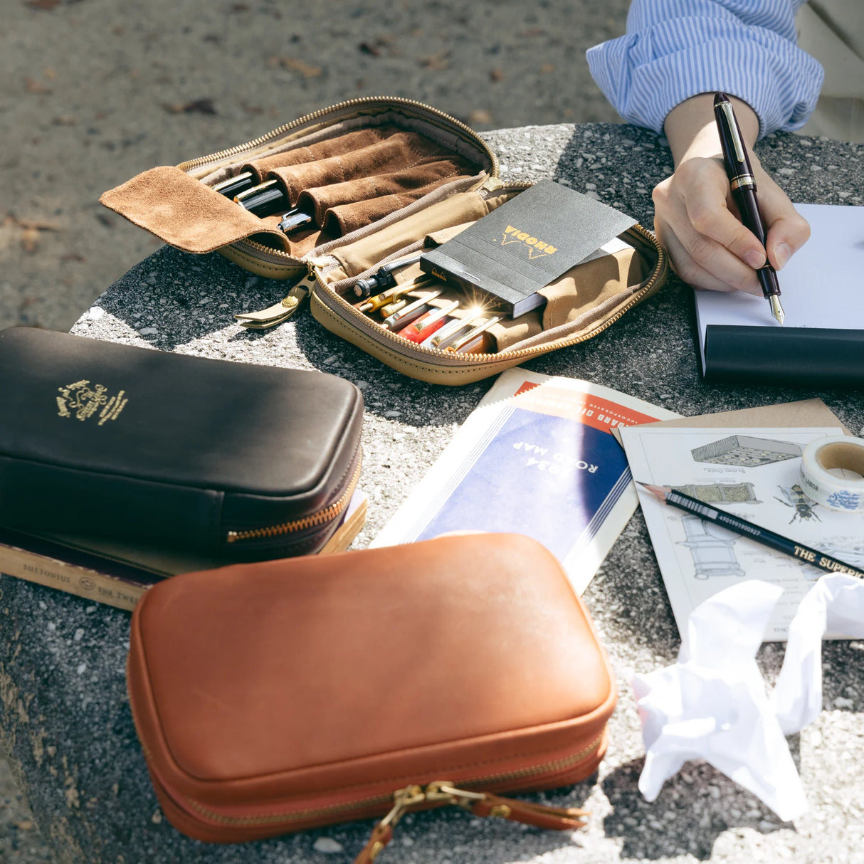 We crafted this leather case for those who love to write —for people who value the quiet moments spent with pen and paper.

Open it up, and on the right side, every surface that touches your precious pens is lined with soft suede, gently protecting them from scratches.&nbsp;On the left, two rows of pockets hold your memo pads, casual pens, or other writing companions, keeping everything neatly in place and ready whenever inspiration strikes.

Size: W13×H20×D4.5cm
About the Leather – Japanese Glove Leather

