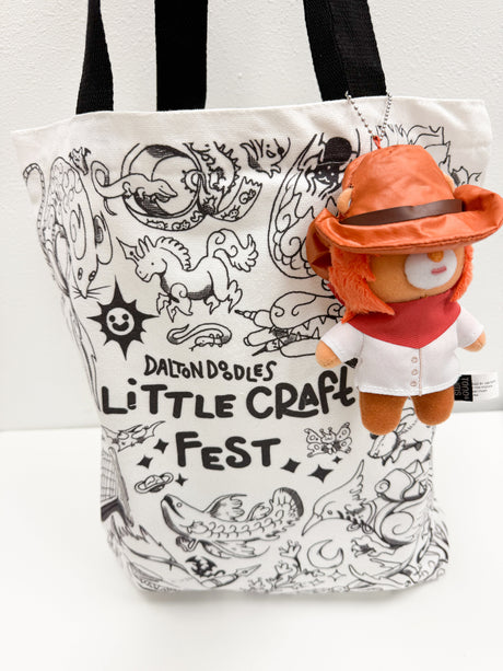 This limited‑edition tote features original artwork from Texas‑based illustrator Dalton Doodles, known for his whimsical characters and imaginative stationery‑inspired designs. Perfect for craft lovers, artists, students, and anyone who enjoys unique accessories, this tote bag blends charm, function, and fandom into one must‑have piece.